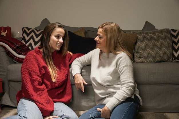 A mother and teenage daughter sitting on a couch, engaged in a heartfelt conversation. Both are listening attentively, showing empathy and understanding.