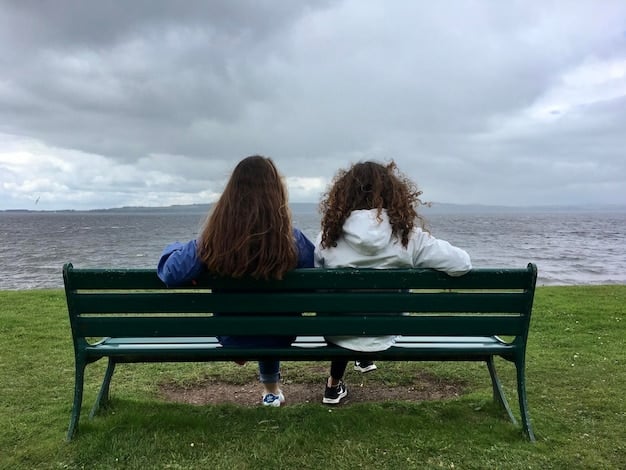 Two friends sitting on a park bench, one comforting the other by patting their back. The scene conveys empathy, support, and closeness between friends.