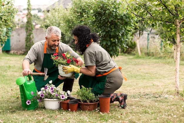 Neighbors planting flowers in a community garden, with gardening tools, soil bags, and colorful flowers spread around, and a community sign in the background.