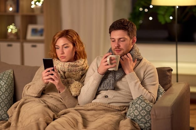 A young couple is sitting on a couch, both looking at their phones but occasionally glancing at each other and smiling. The lighting is warm, and the atmosphere is comfortable and relaxed.