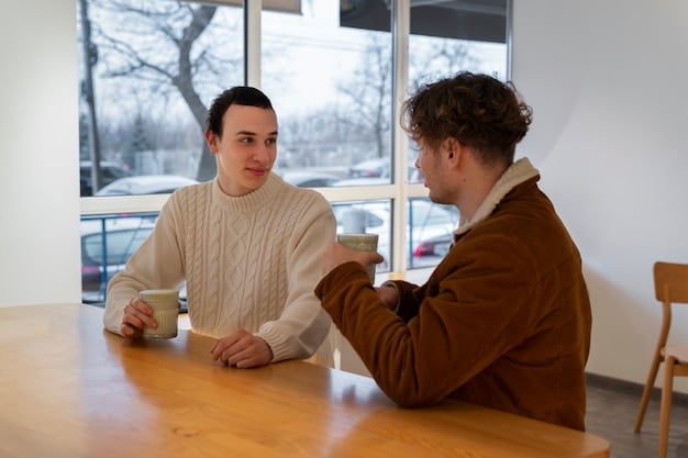 Two people are sitting face to face at a cafe table, deeply engaged in a conversation. They are making eye contact and gesturing with their hands, indicating an active and empathetic discussion.