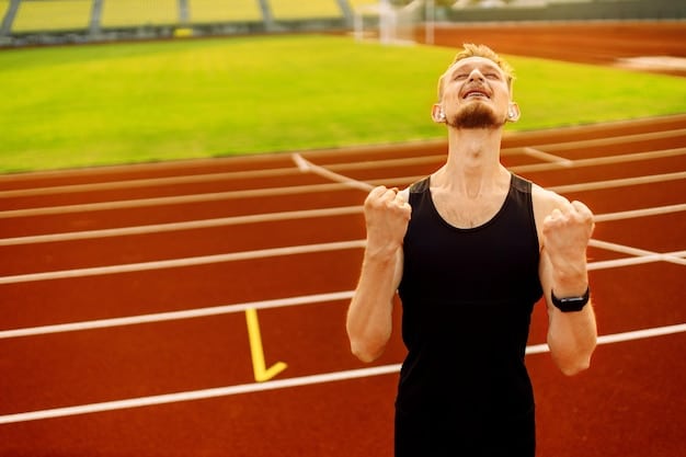 A US track and field runner bursting from the starting blocks, with the blurred outline of a stadium crowd in the background, showing intense focus.