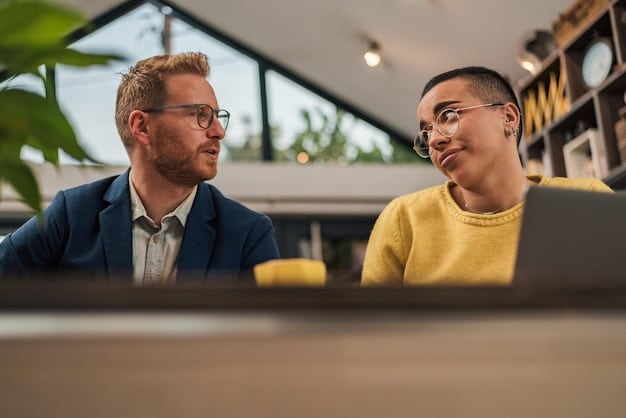 Two individuals maintaining appropriate eye contact during a business meeting, conveying professionalism and attentive listening in a brightly lit office setting.